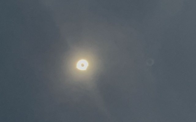 The eclipsed sun seen through thin cloud in April 2024