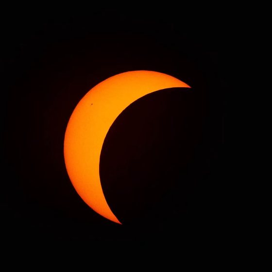 The sun as a thick orange crescent early in the partial phase