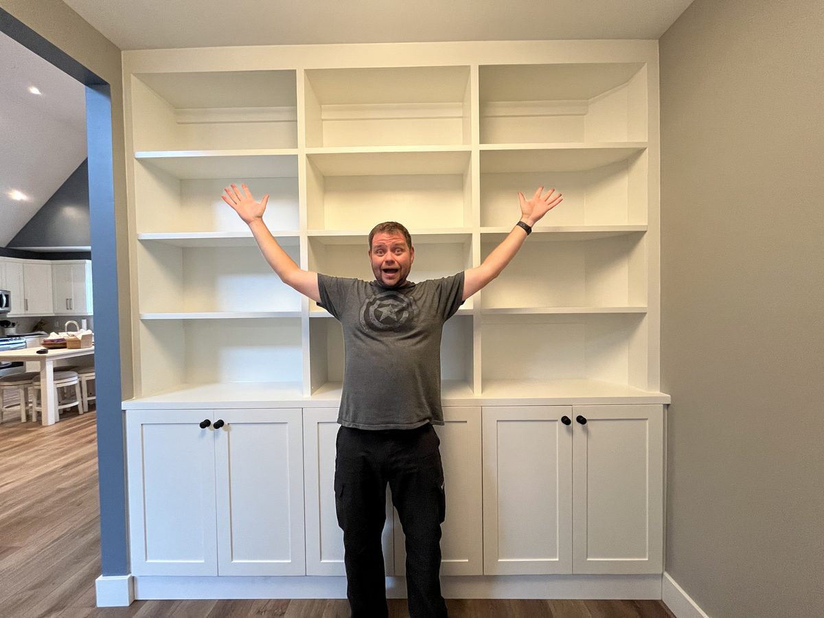 Trevor celebrating in front of the finished shelves